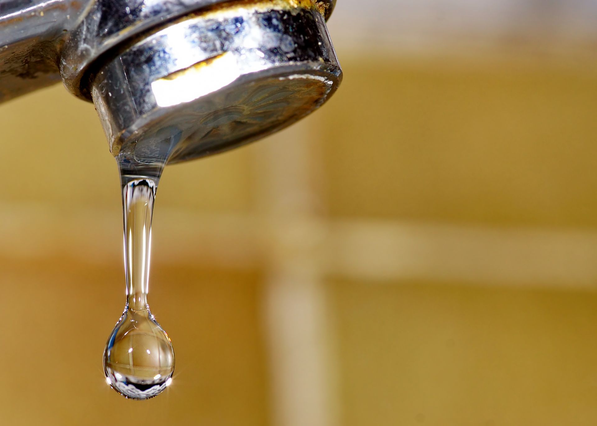 Water droplet falling from a leaky faucet.