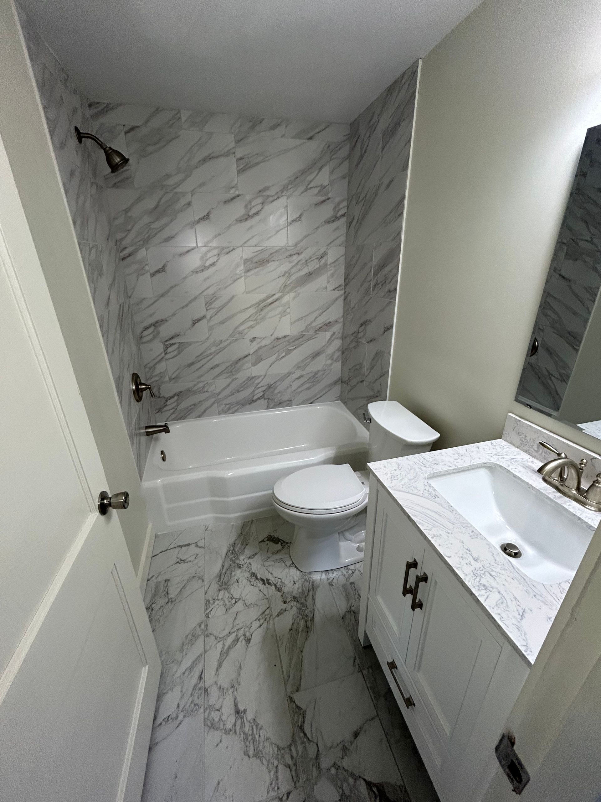 Modern bathroom with a bathtub, toilet and vanity.