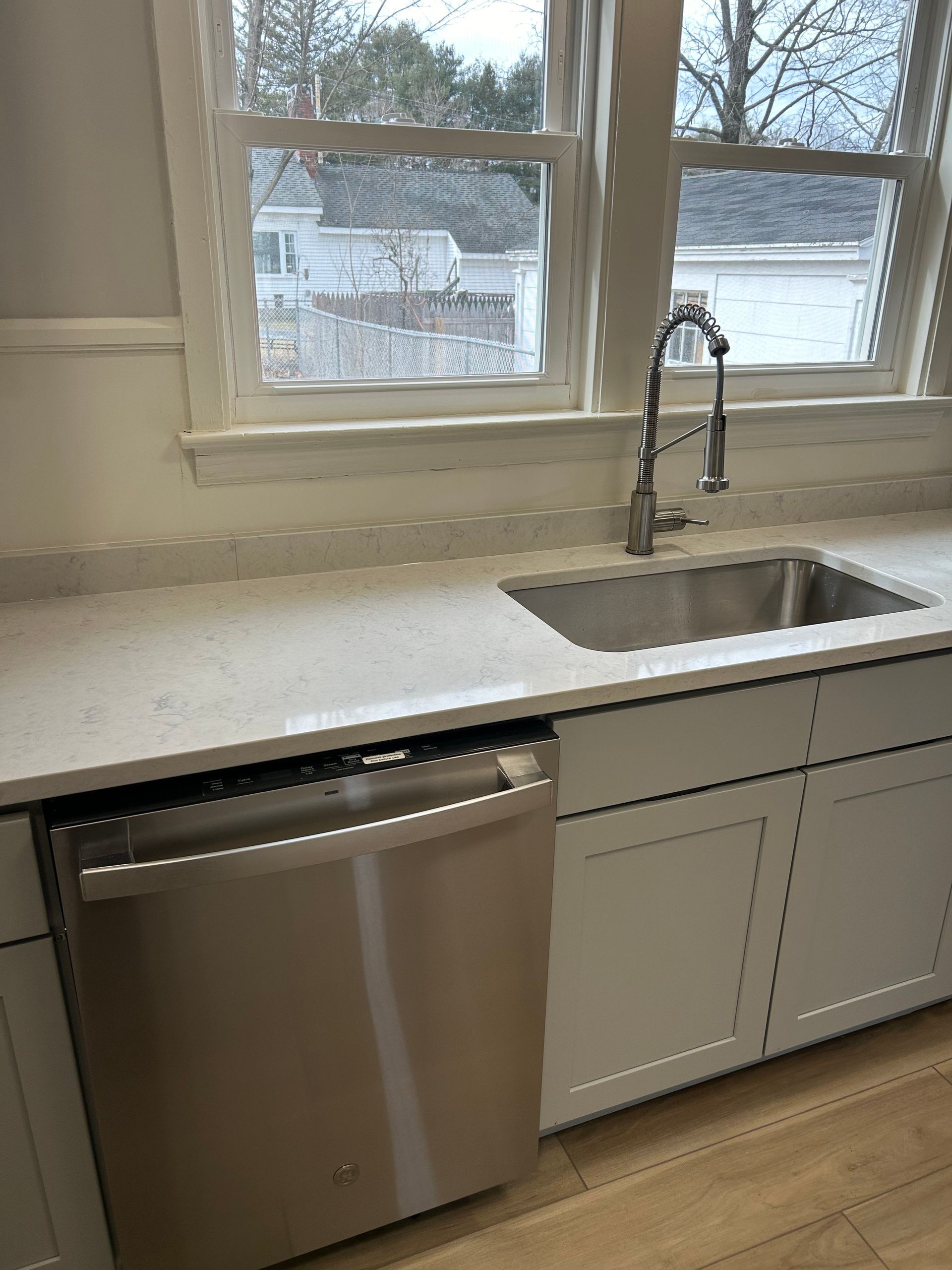 Kitchen sink with pull-down faucet and a built-in dishwasher.
