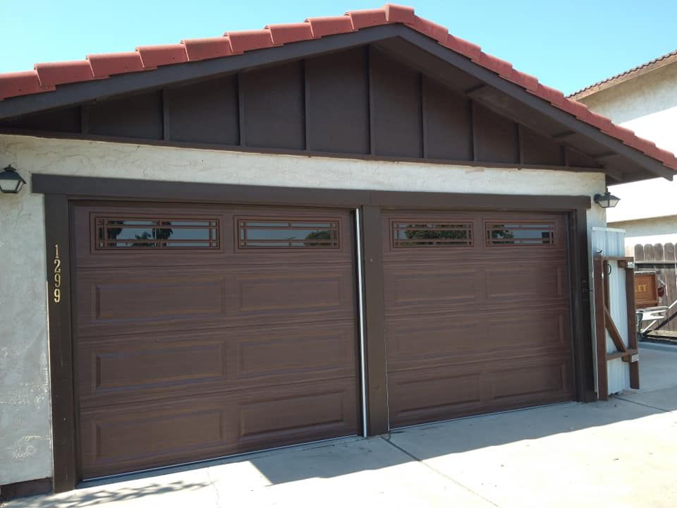 A brown garage door with a red tile roof