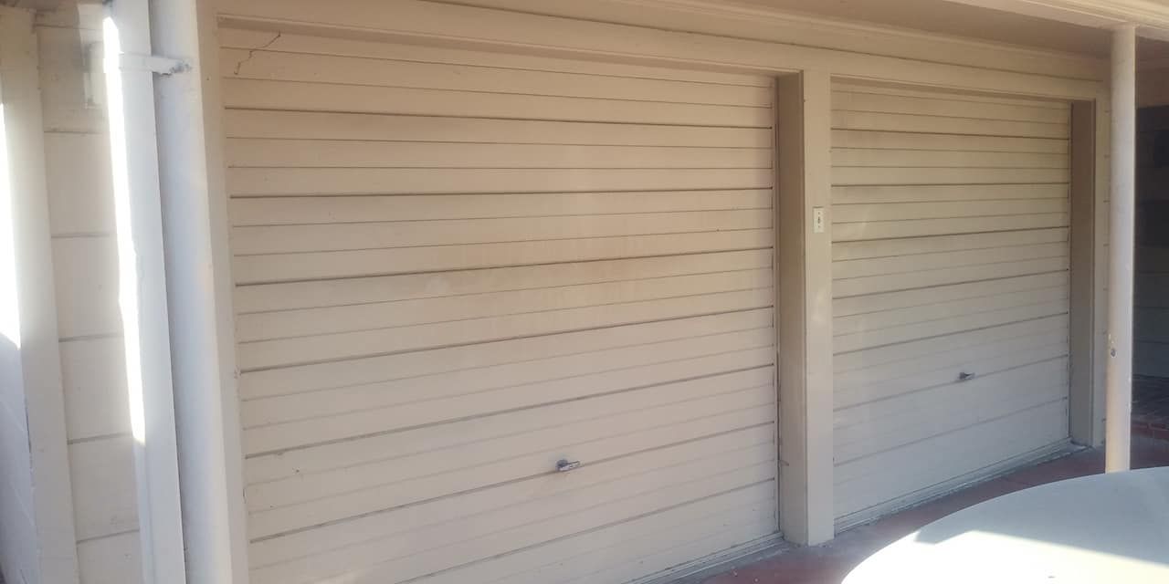 A white wall with a door in the middle of it.