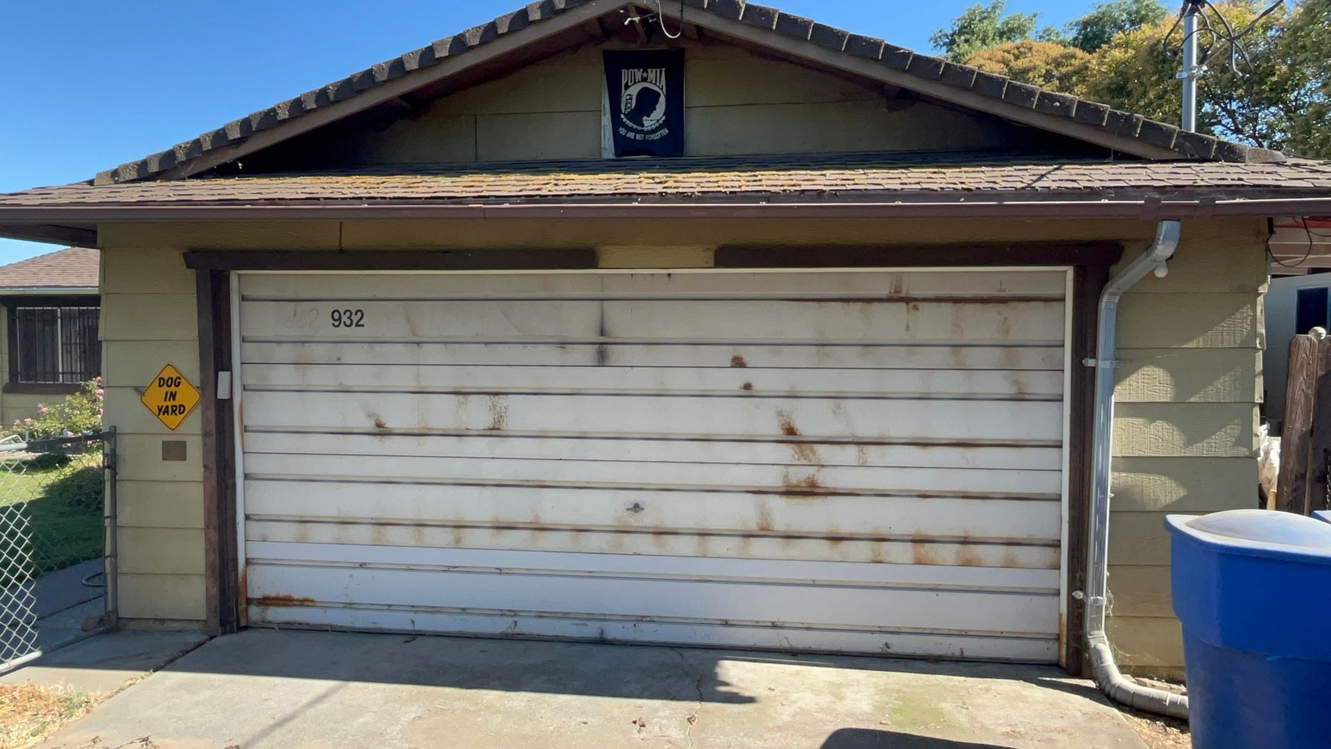 A white garage door is sitting in front of a house.