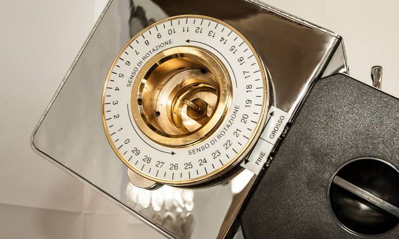 Un primo piano di un macinacaffè con un orologio sopra