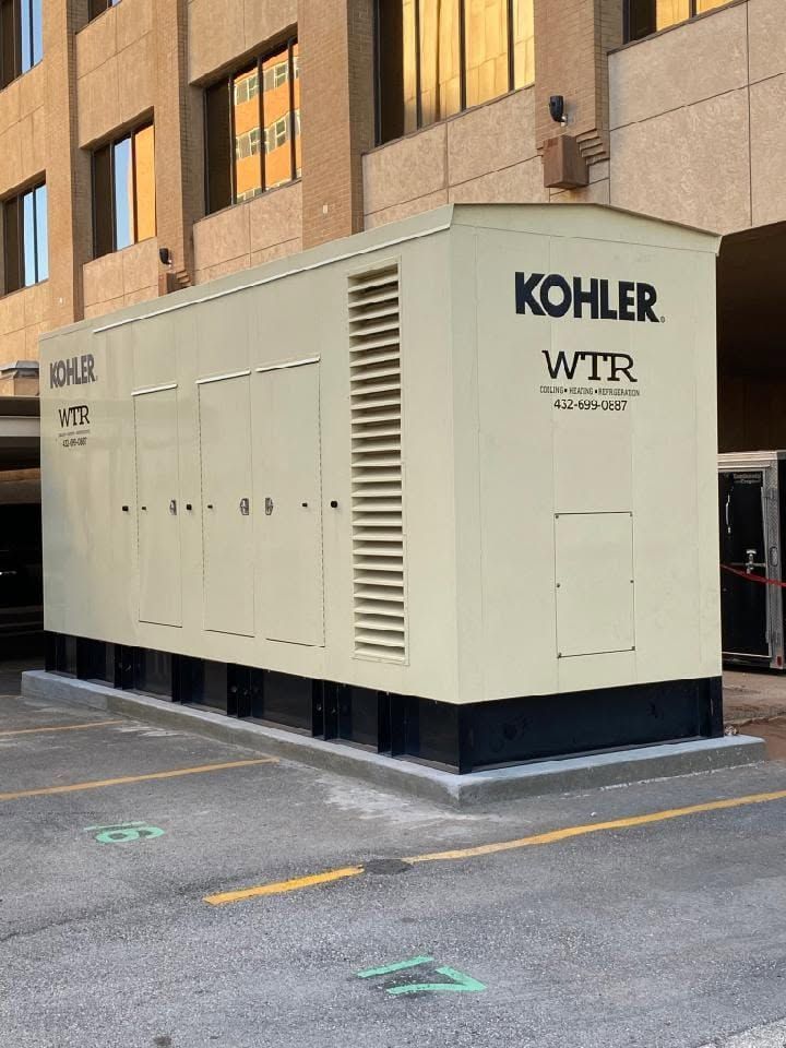 A kohler wtr generator is sitting in a parking lot next to a building.