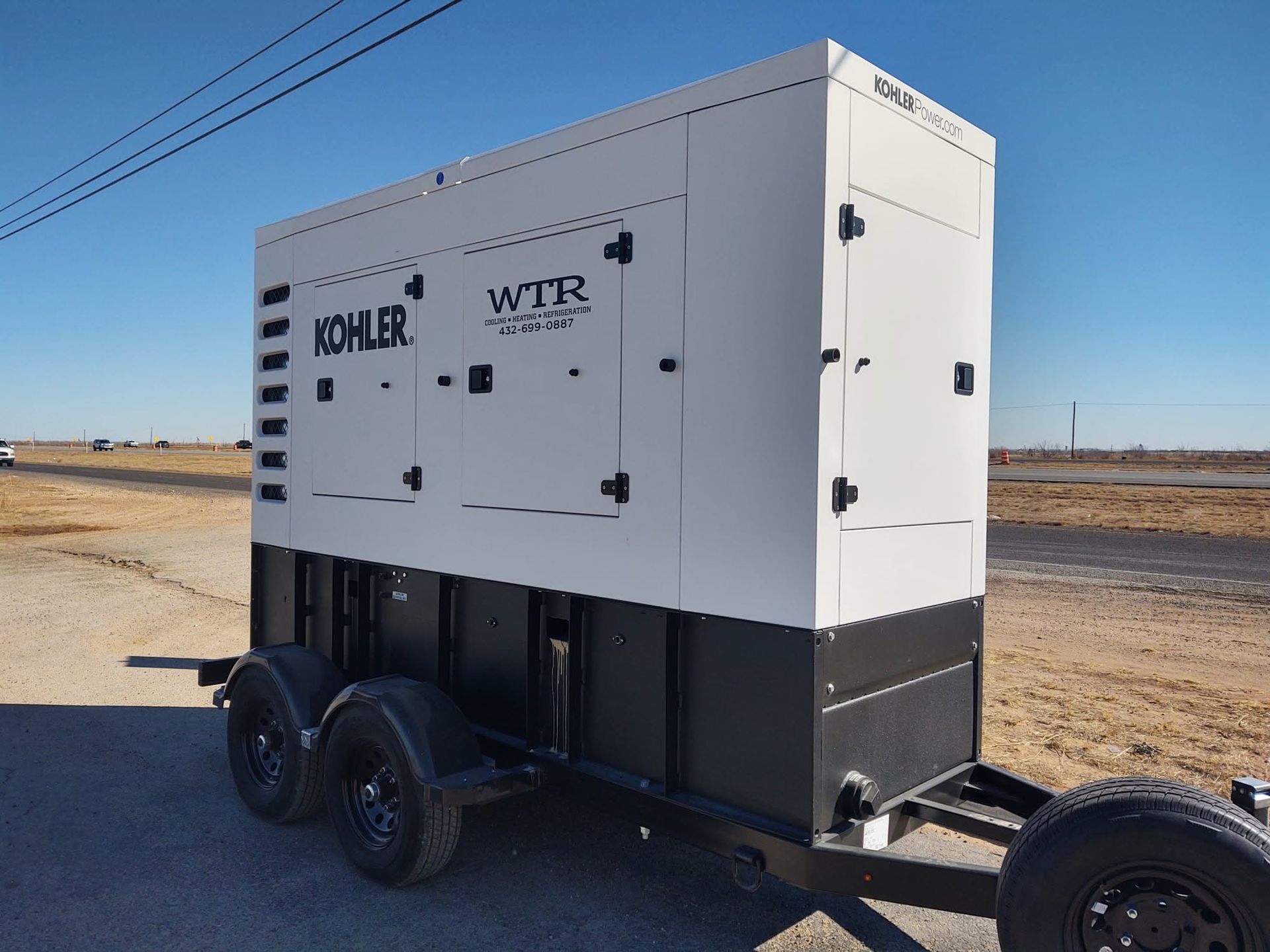 A white and black kohler generator on a trailer