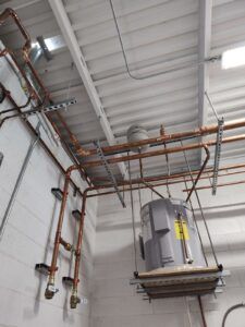 A room with a lot of pipes hanging from the ceiling.