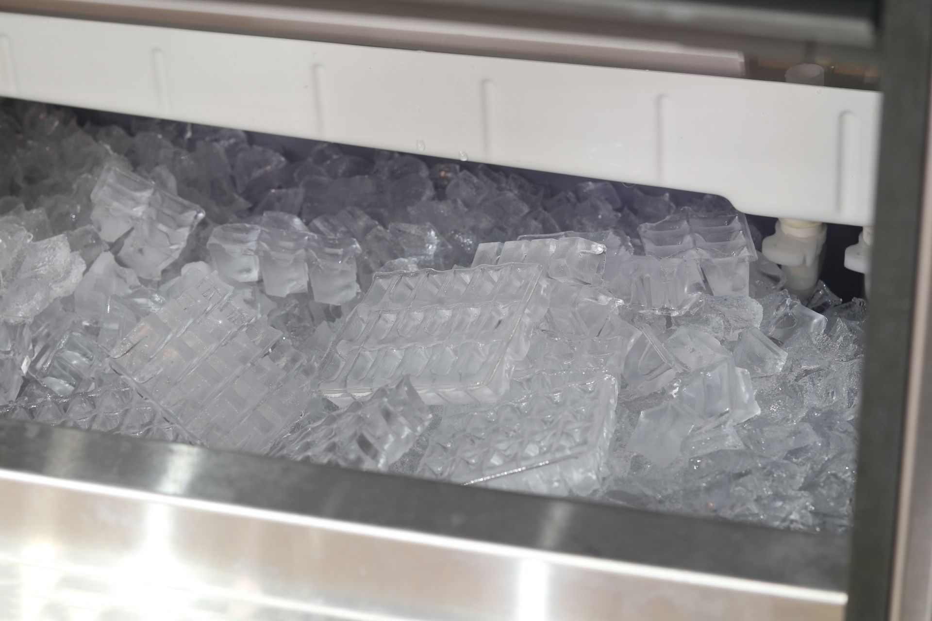A stainless steel drawer filled with ice cubes.