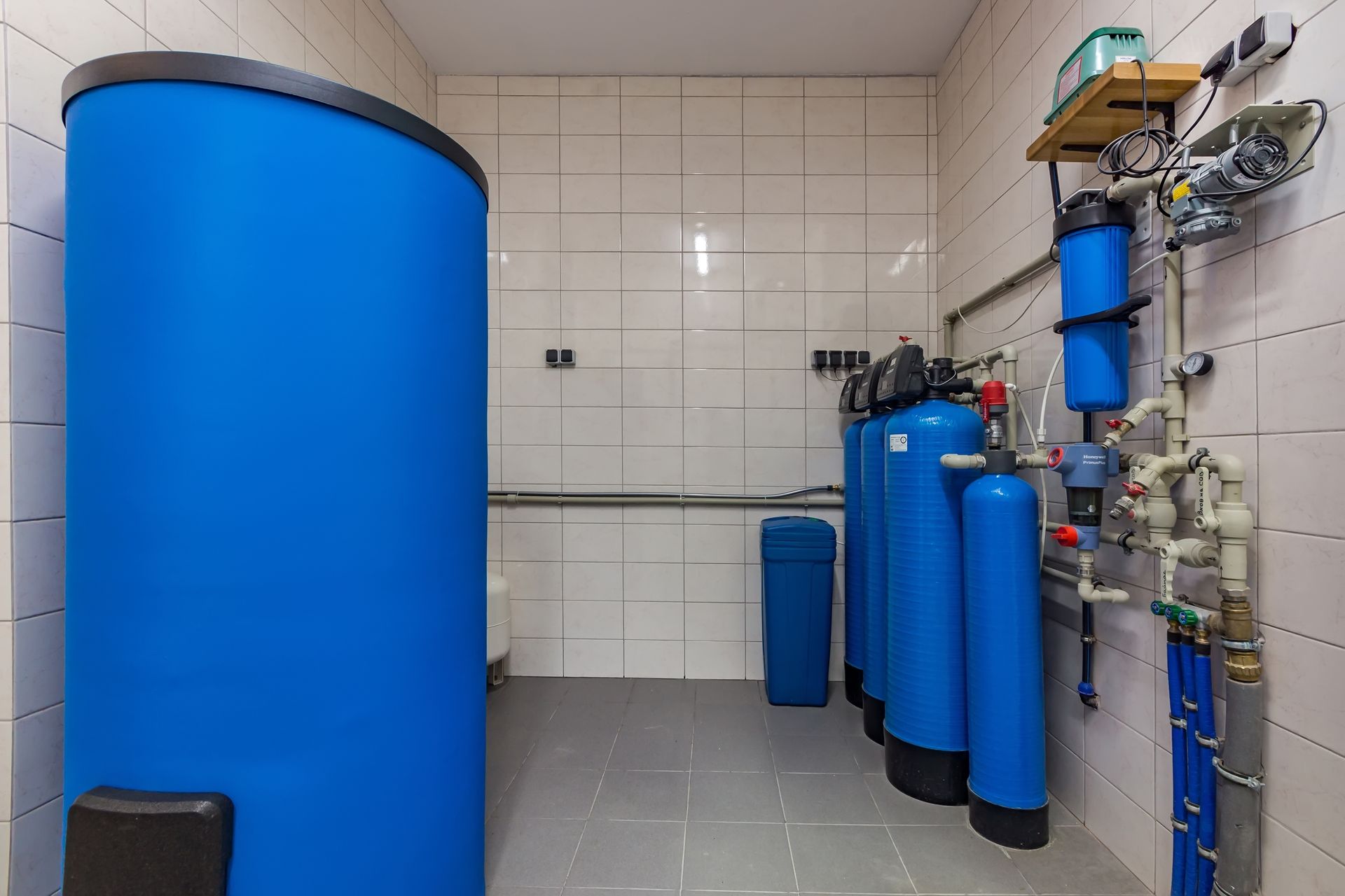 A room with a lot of blue tanks and pipes.