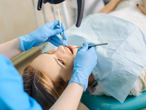 Cleaning — Female Dentist Treating Caries in Bangor, ME