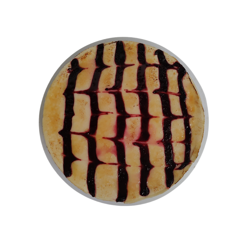 Crepe con un chorrito de sirope oscuro en forma de cuadrícula de Azúcar y Cacao