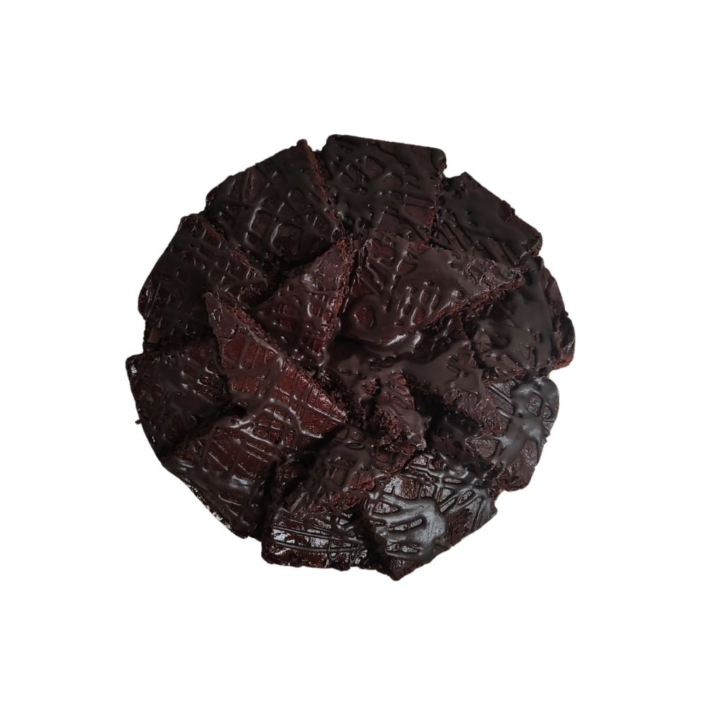 Pastel de chocolate con trozos de brownie encima, rociado con glaseado de chocolate, sobre un plato blanco de Azúcar y Cacao