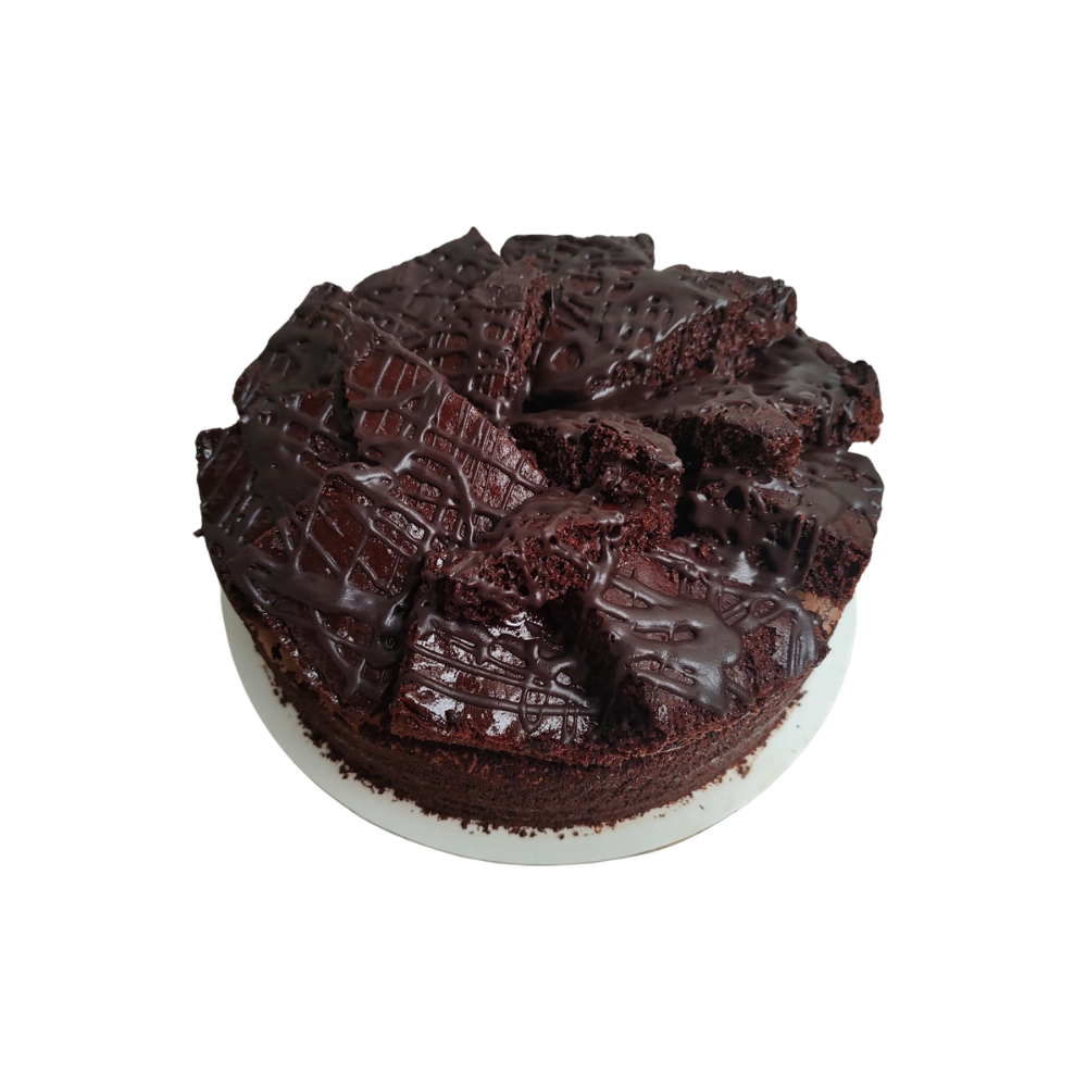 Pastel de chocolate cubierto con trozos de brownie y rociado con chocolate de Azúcar y Cacao