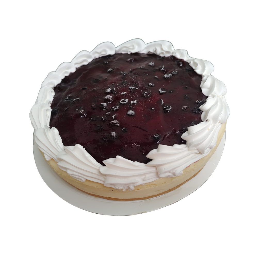 Tarta de queso con cobertura de arándanos y borde de crema batida sobre un plato blanco de Azúcar y Cacao