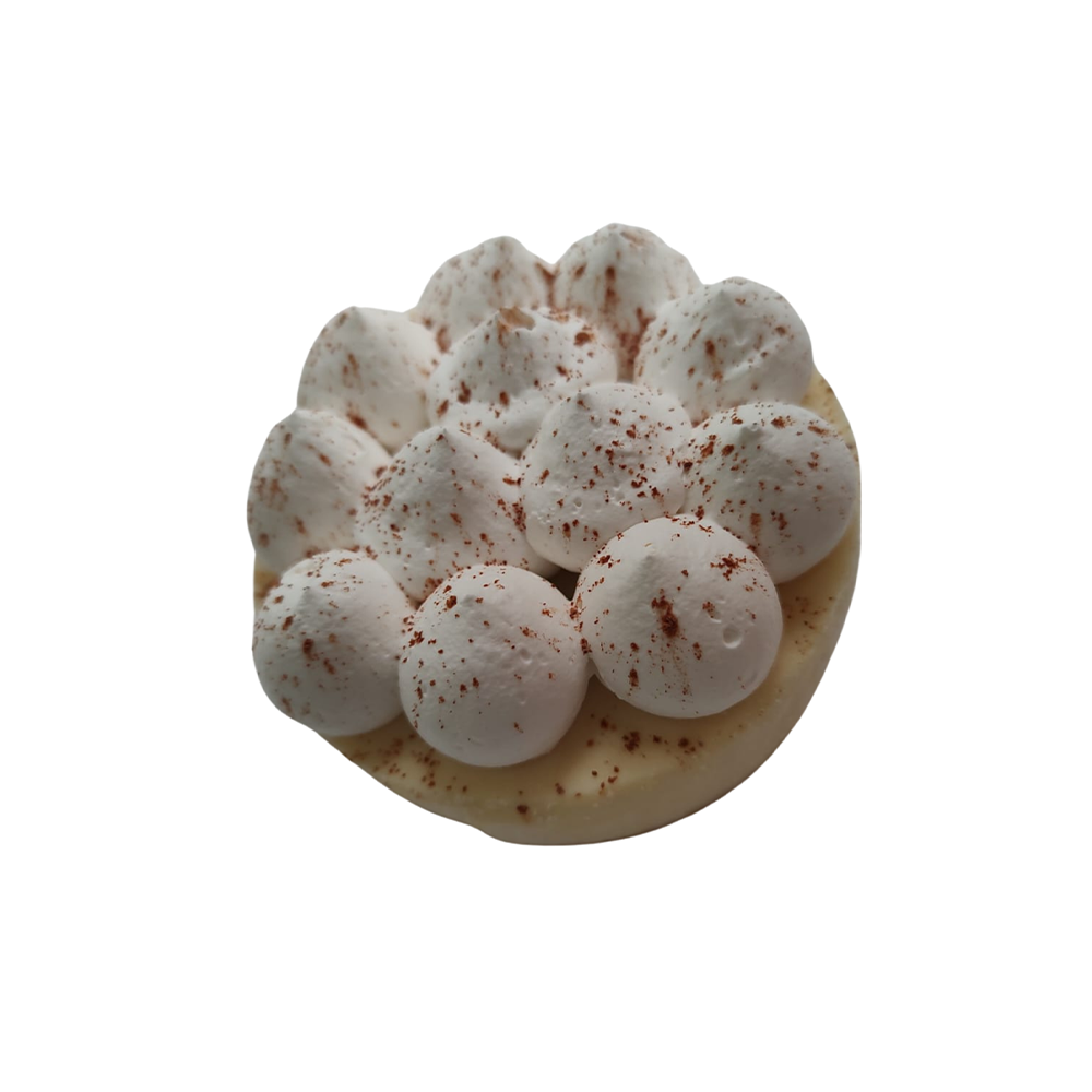 Una pequeña tarta con cubierta de merengue blanco, espolvoreada con polvo marrón de Azúcar y Cacao