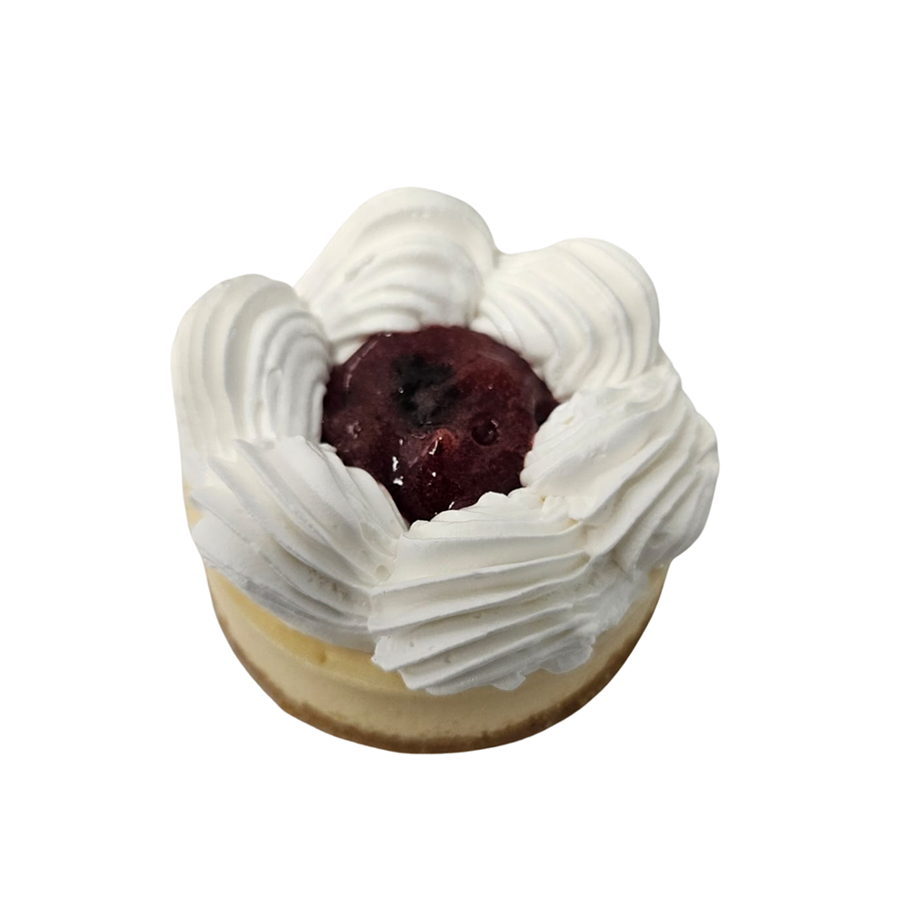 Mini tarta de queso cubierta con crema batida y compota de cerezas  de Azúcar y Cacao