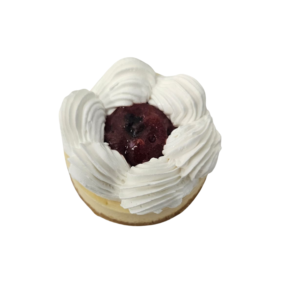 Tarta de queso cubierta con crema batida y compota de cerezas  de Azúcar y Cacao