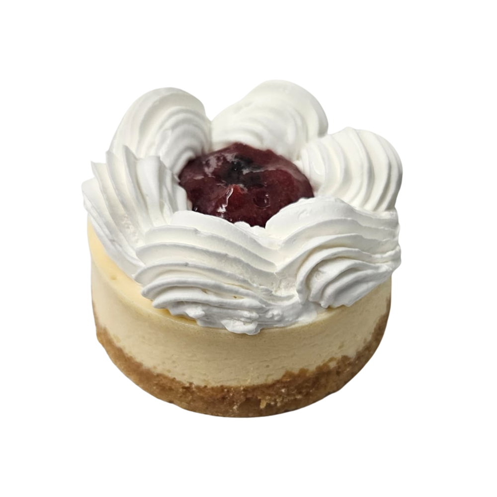 Mini tarta de queso cubierta con crema batida y una cereza  de Azúcar y Cacao