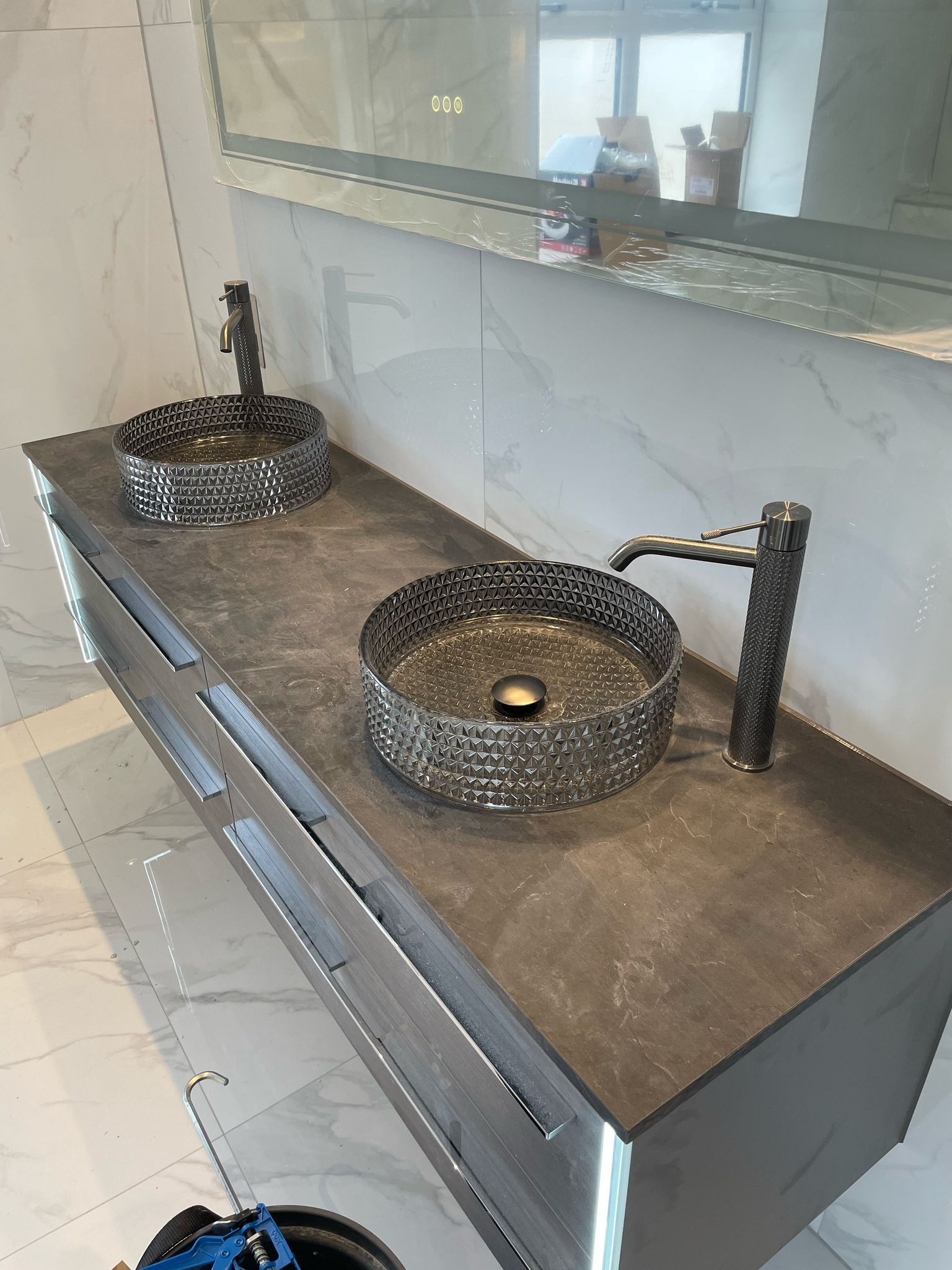 Double bathroom sinks with black fixtures on a gray vanity, with large mirror in a modern bathroom.