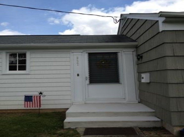 A white house with a small american flag in front of it