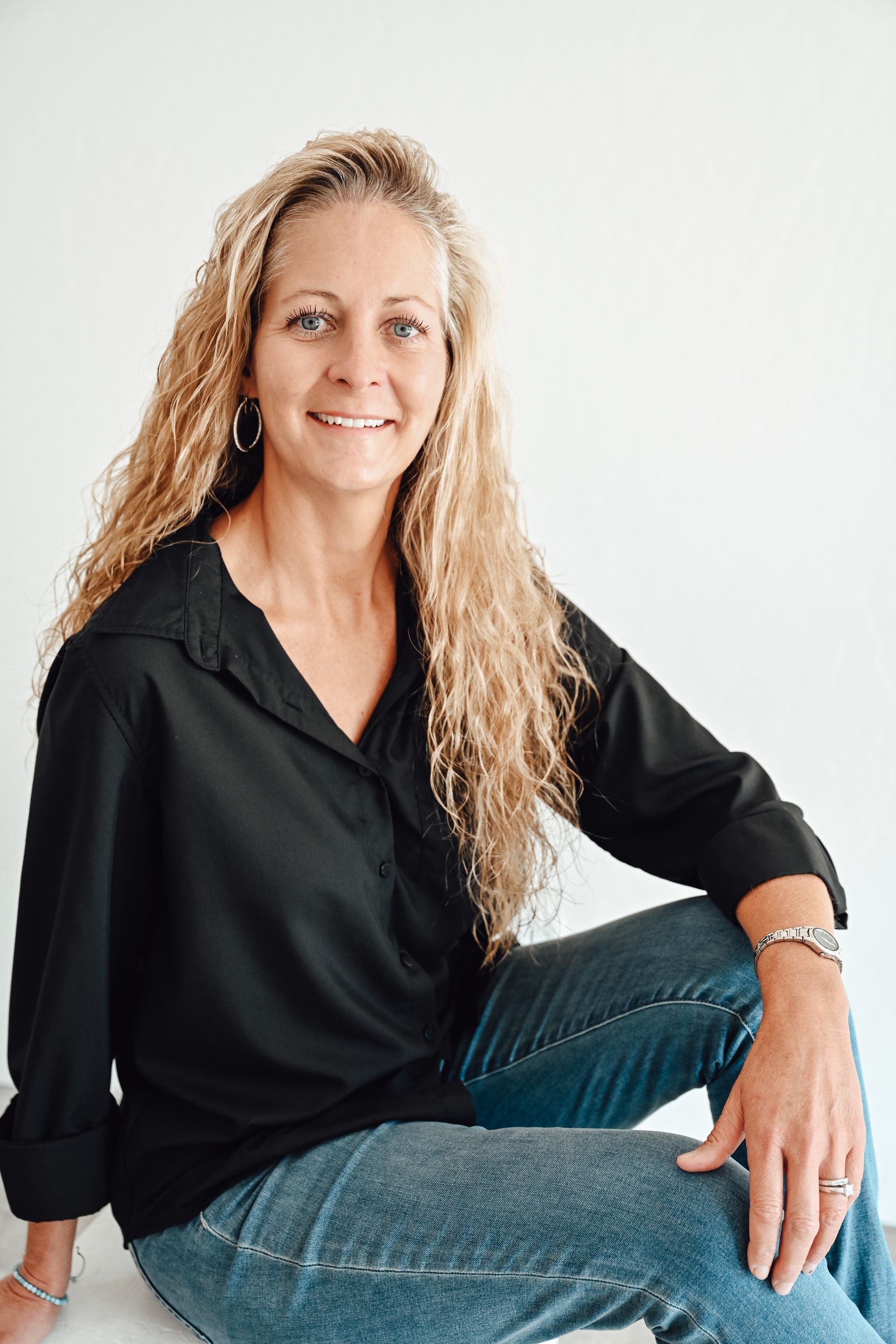 A man is holding a dog in his arms and the dog is wearing a sweater.