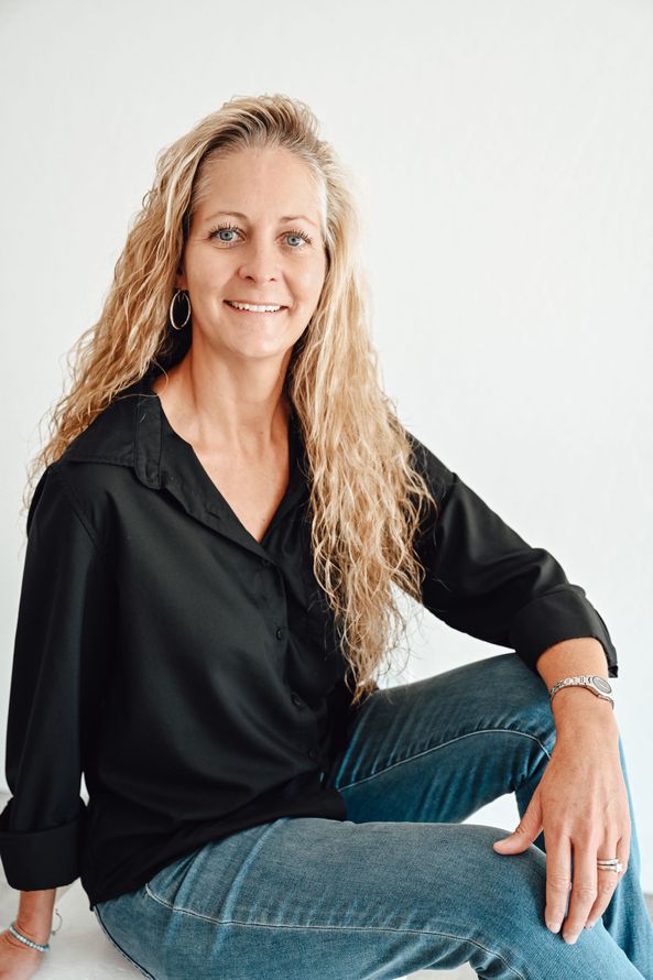 A man is holding a dog in his arms and the dog is wearing a sweater.