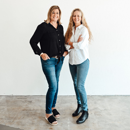 Two women are posing for a picture together in the desert.