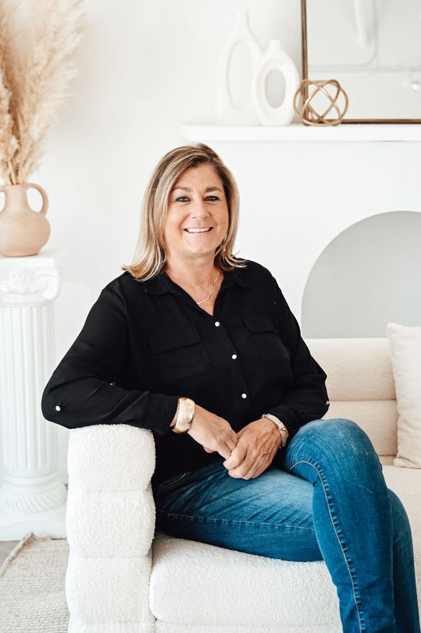 A man is holding a dog in his arms and the dog is wearing a sweater.