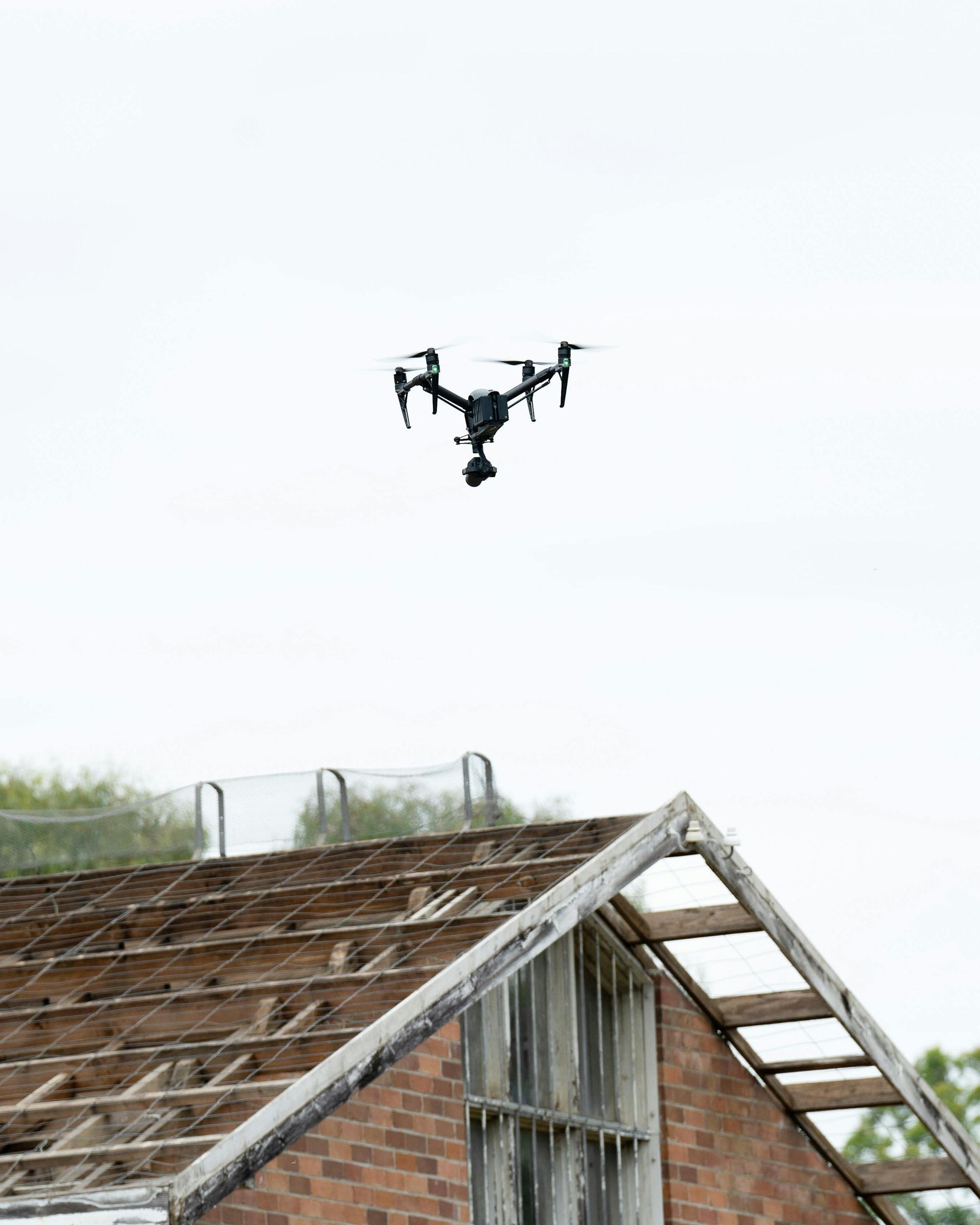 Drone inspecting storm-damaged roof for insurance claim assessment