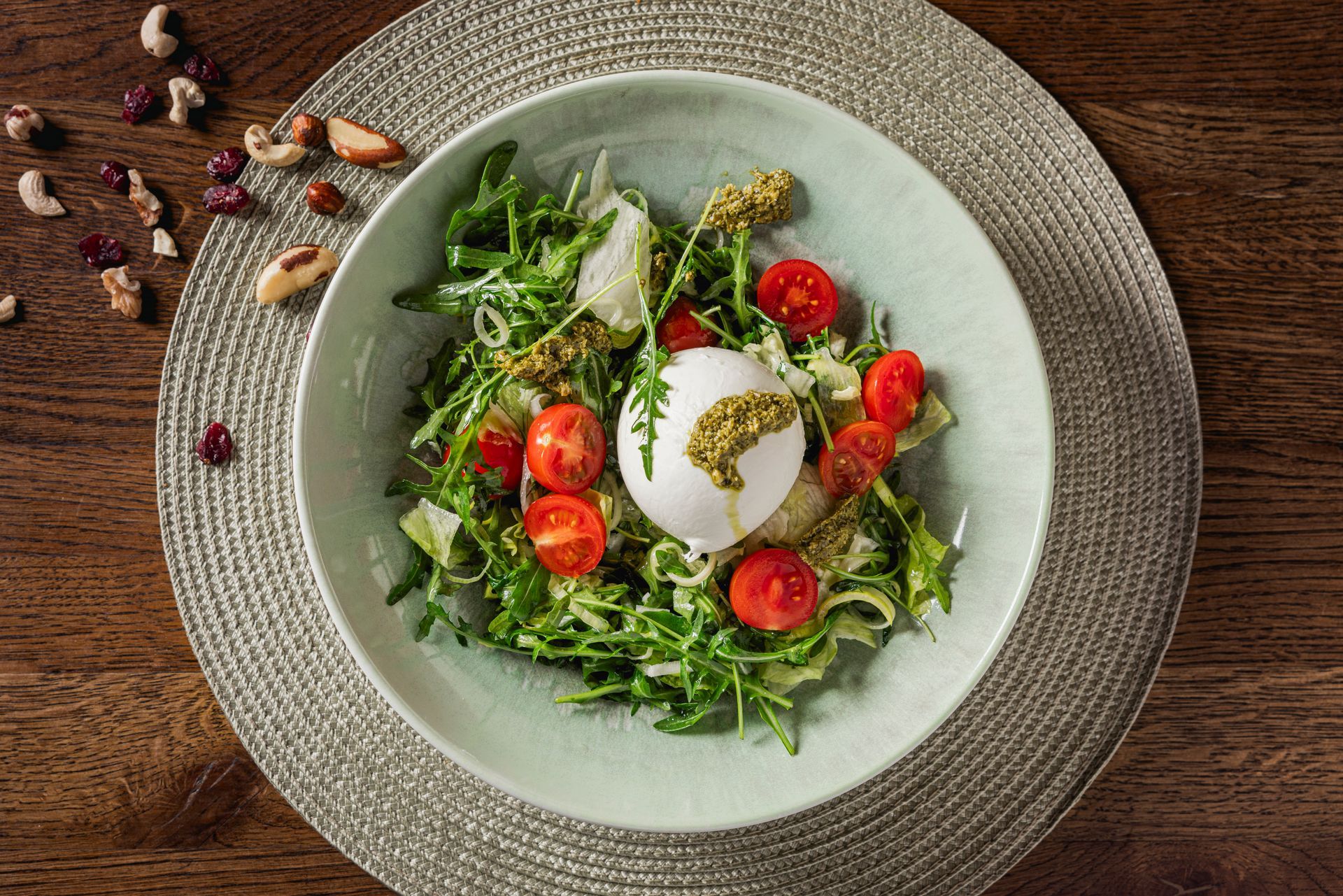 Ein Salat in einer Schüssel auf einem Platzdeckchen auf einem Holztisch.