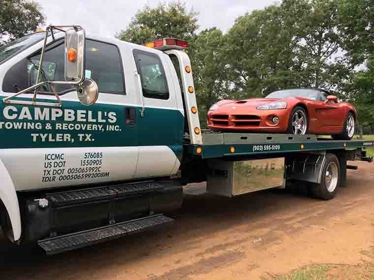 Sports car on a tilt-bed tow truck
