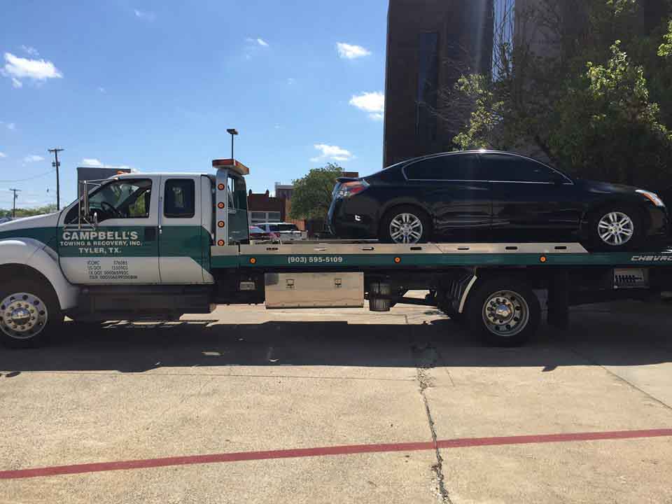 Car being hauled on flatbed truck