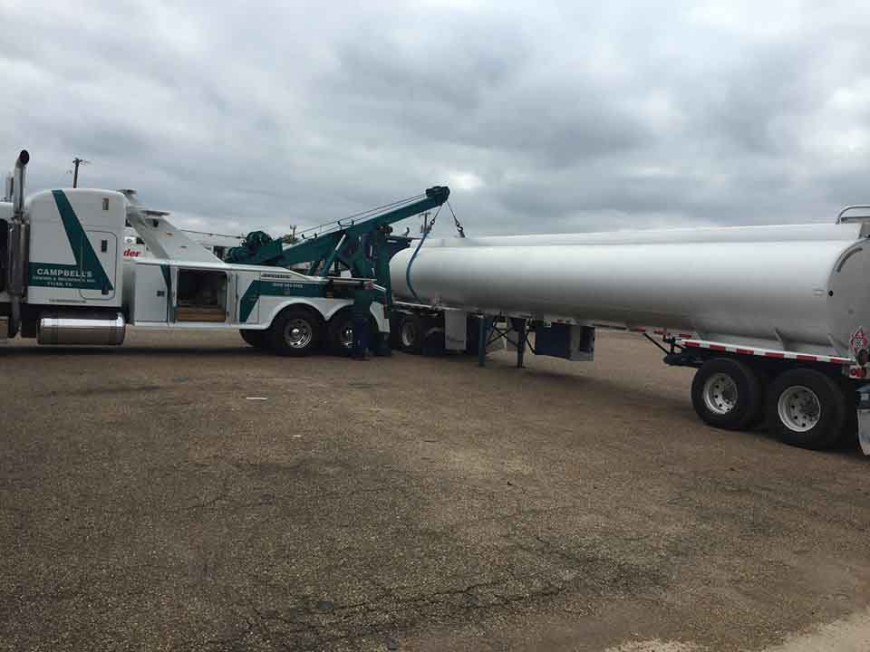 Heavy-duty tow truck hauling tanker truck
