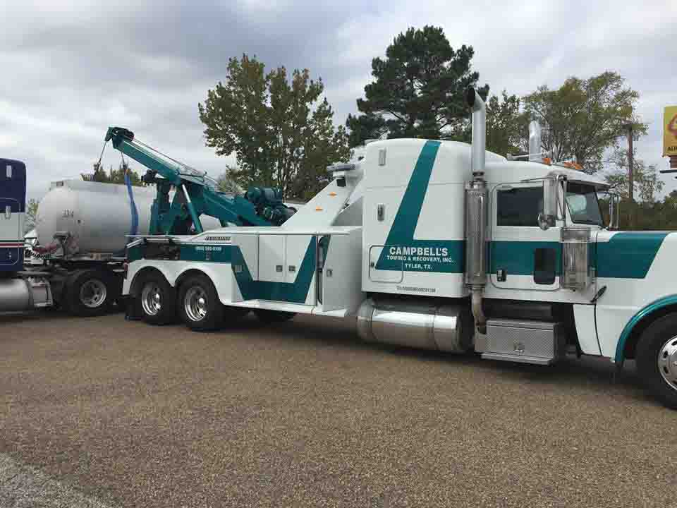 Heavy-duty tow truck recovering a tanker truck