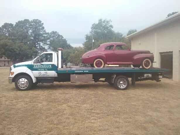 Flatbed truck hauling antique car