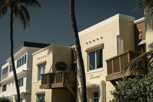 Buildings in warm yellow and white with palm trees, sunny day.