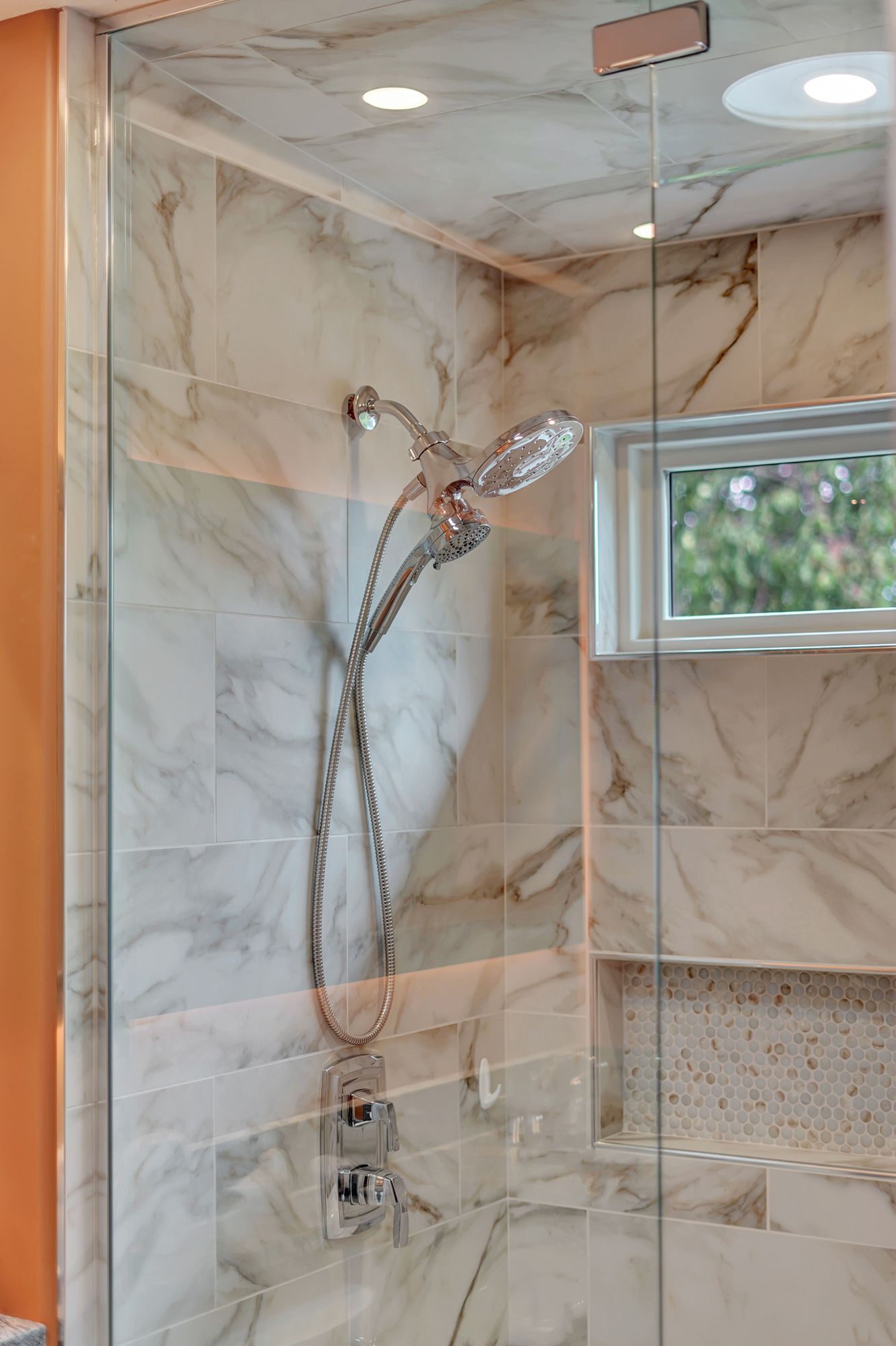 A shower stall with a glass door and a shower head.