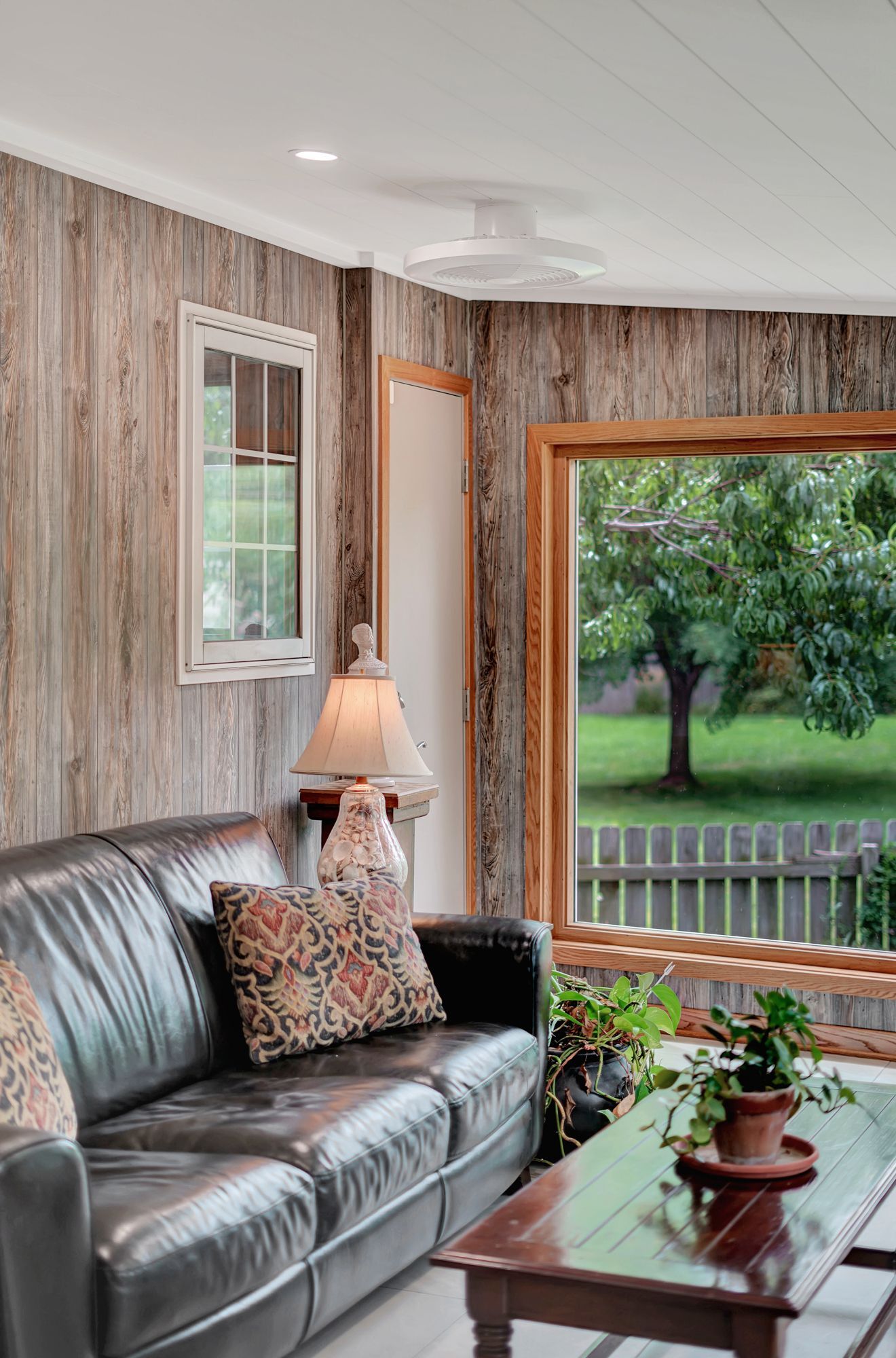 A living room with a couch , coffee table , and window.