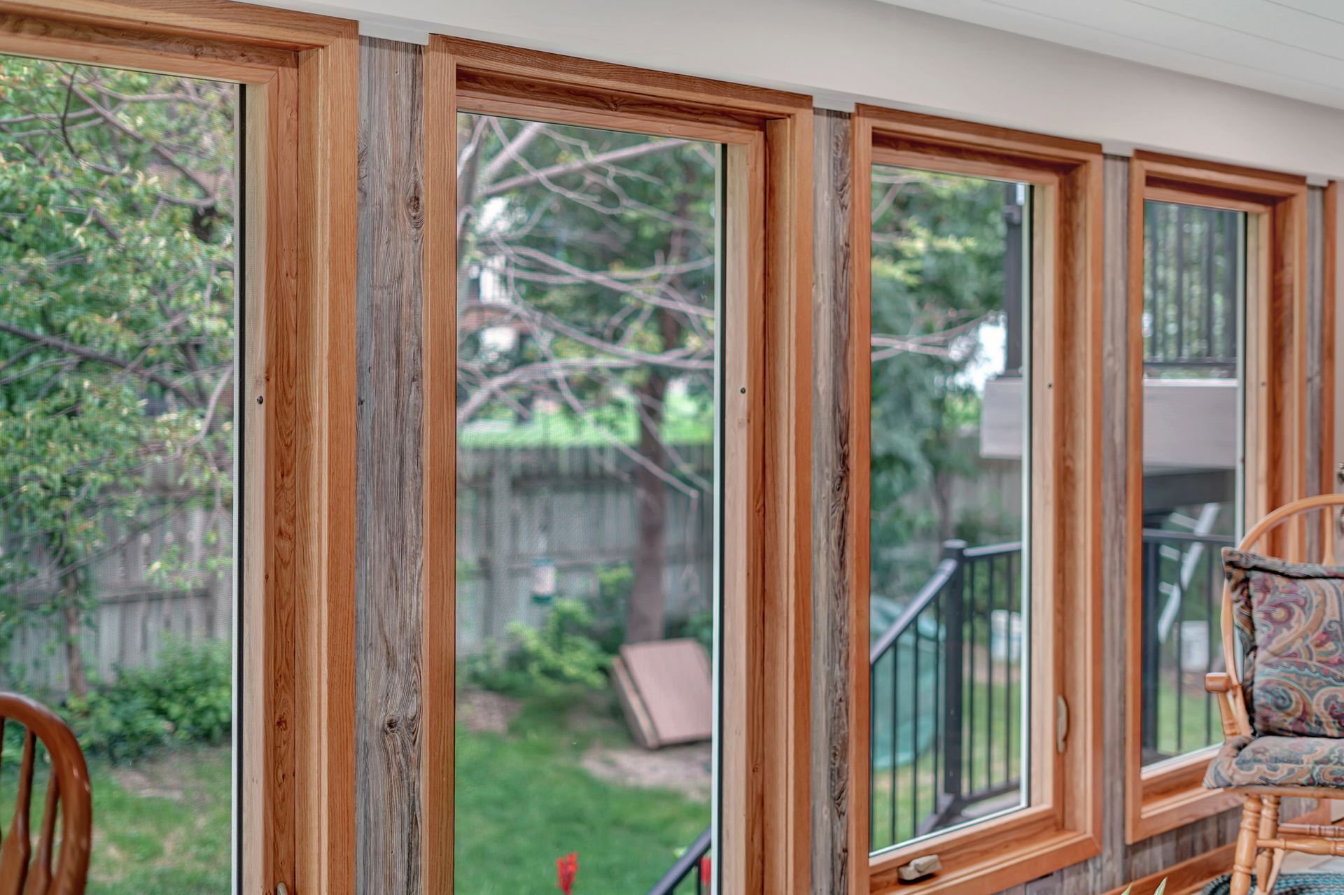 A sun room with lots of windows and a rocking chair.