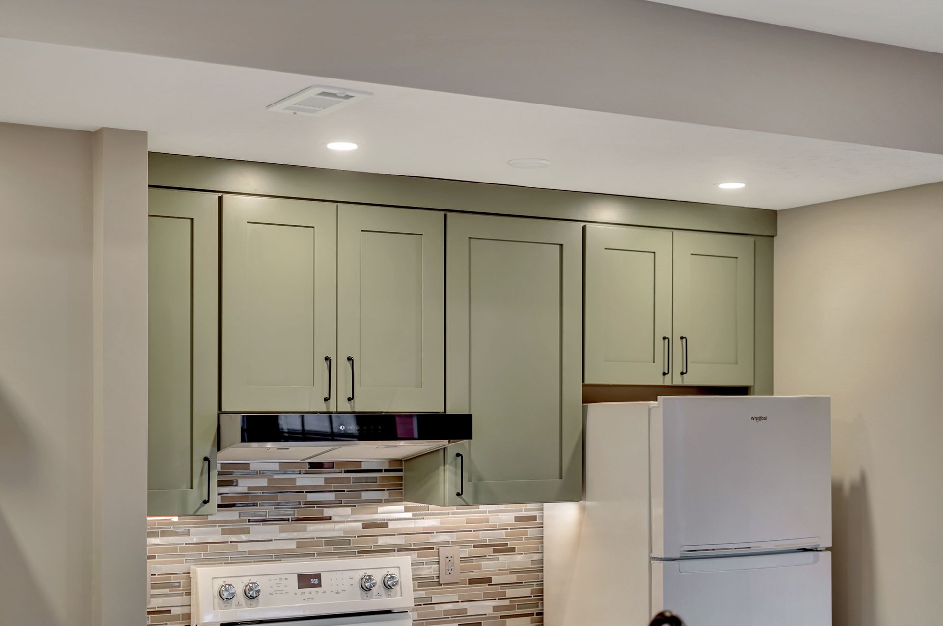 A kitchen with green cabinets and a white refrigerator | Lincoln, NE | SkyLimit Remodeling
