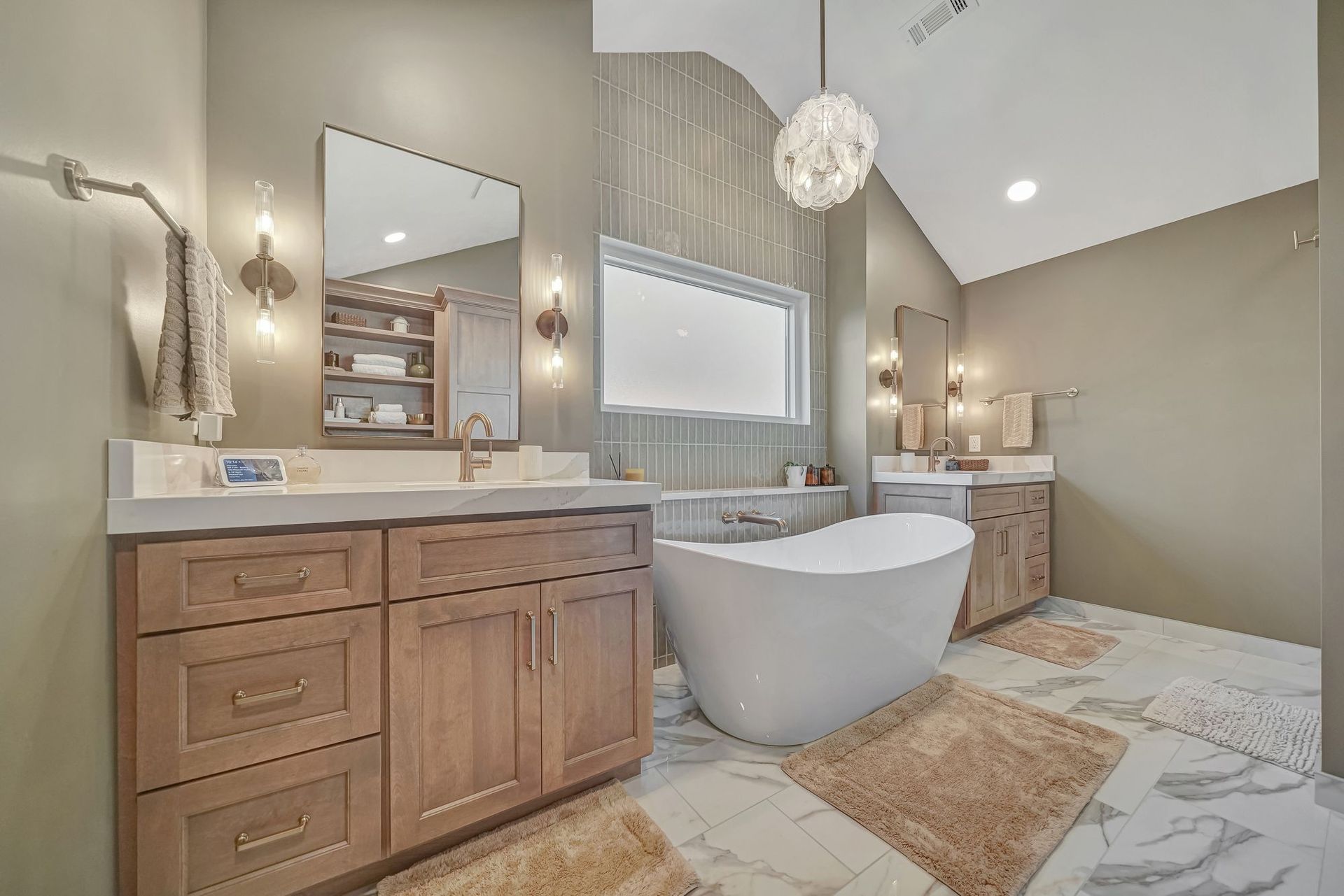 Spacious modern bathroom with a white soaking tub, two wood vanities, and beige walls.