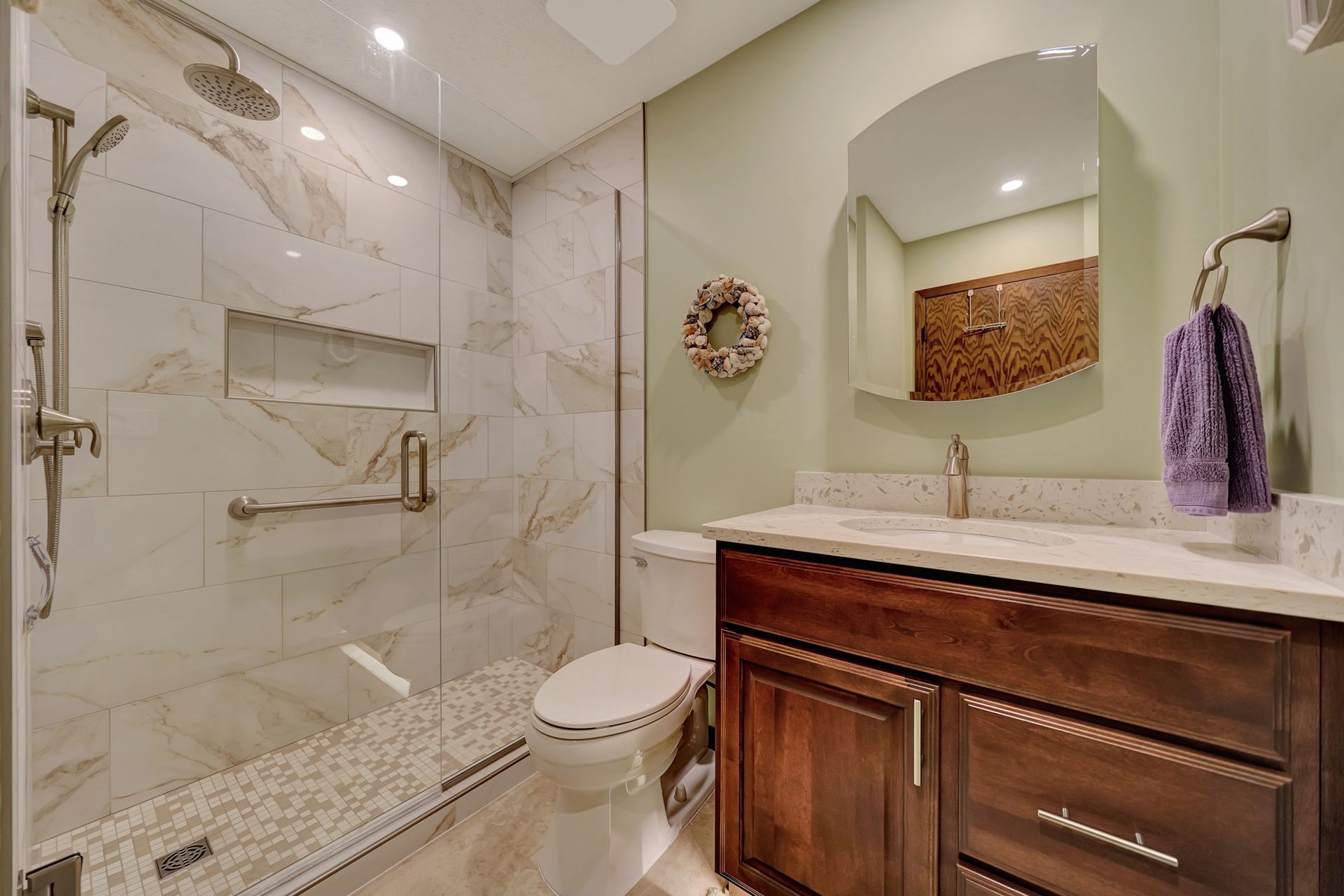 A Bathroom with a Toilet, Sink, Shower and Mirror | Lincoln, NE | SkyLimit Remodeling