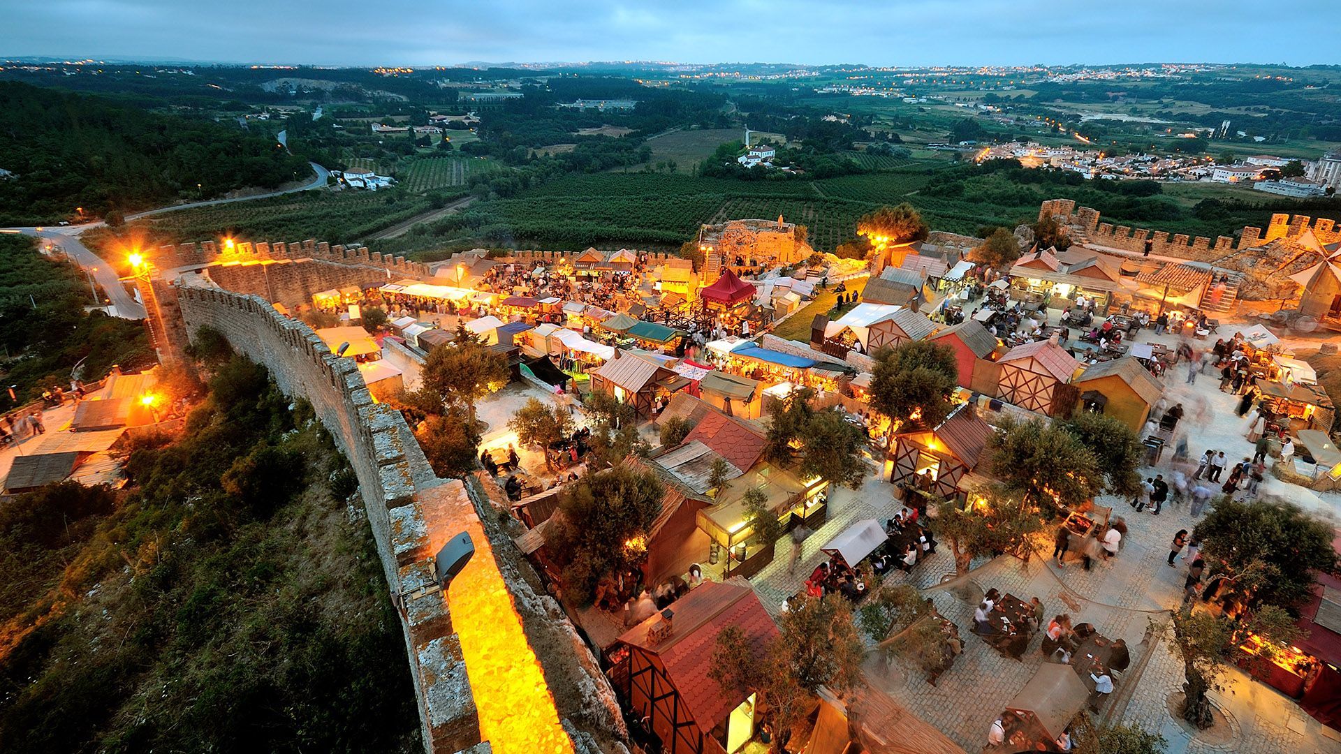 An aerial view of a medieval village at night.