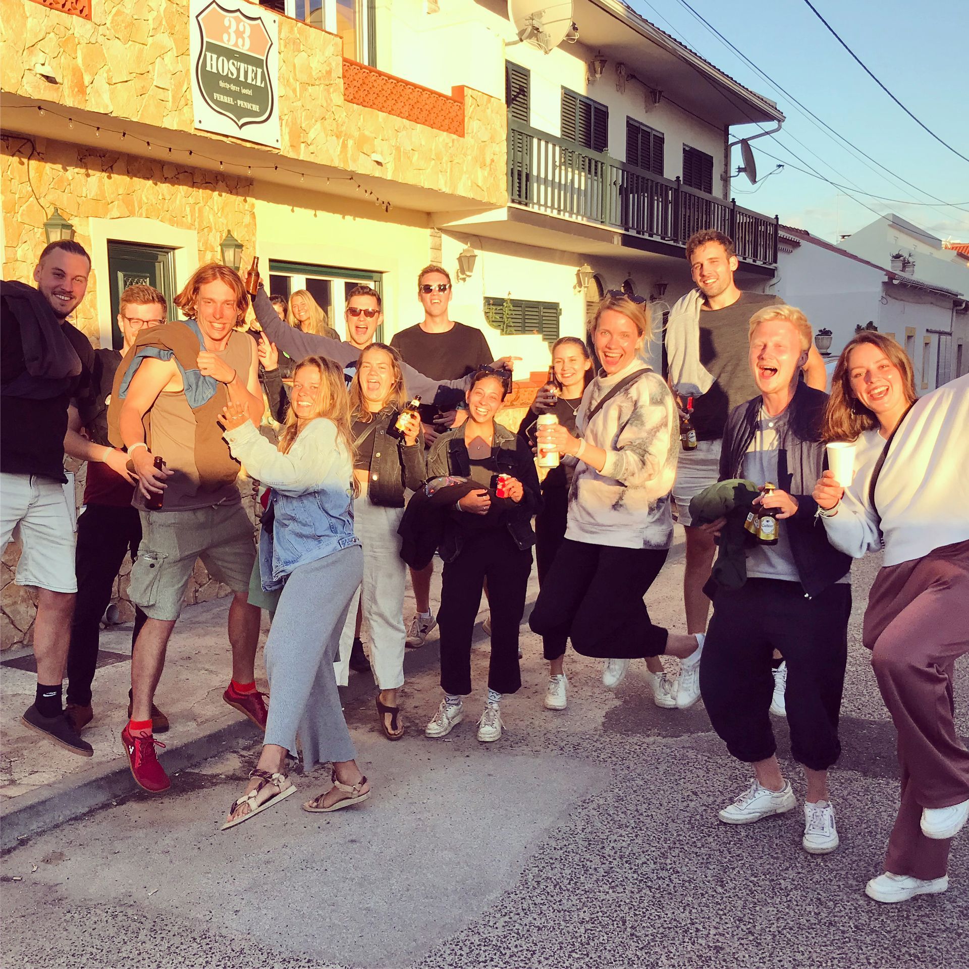 A group of people are posing for a picture in front of a building that has the word hotel on it