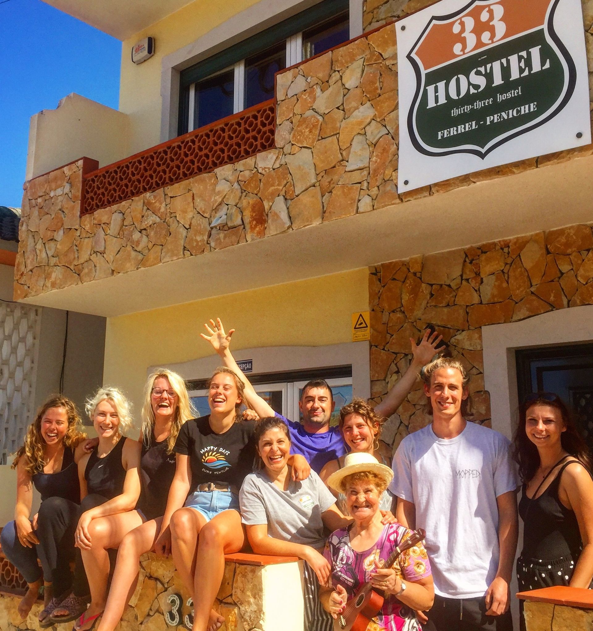 A group of people are posing for a picture in front of the 33 hostel