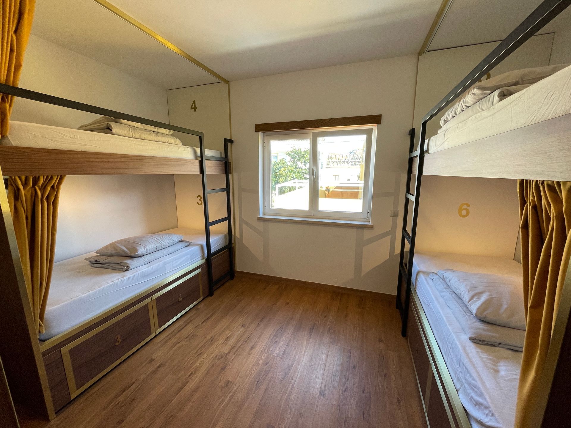 A room with four bunk beds and a window.
