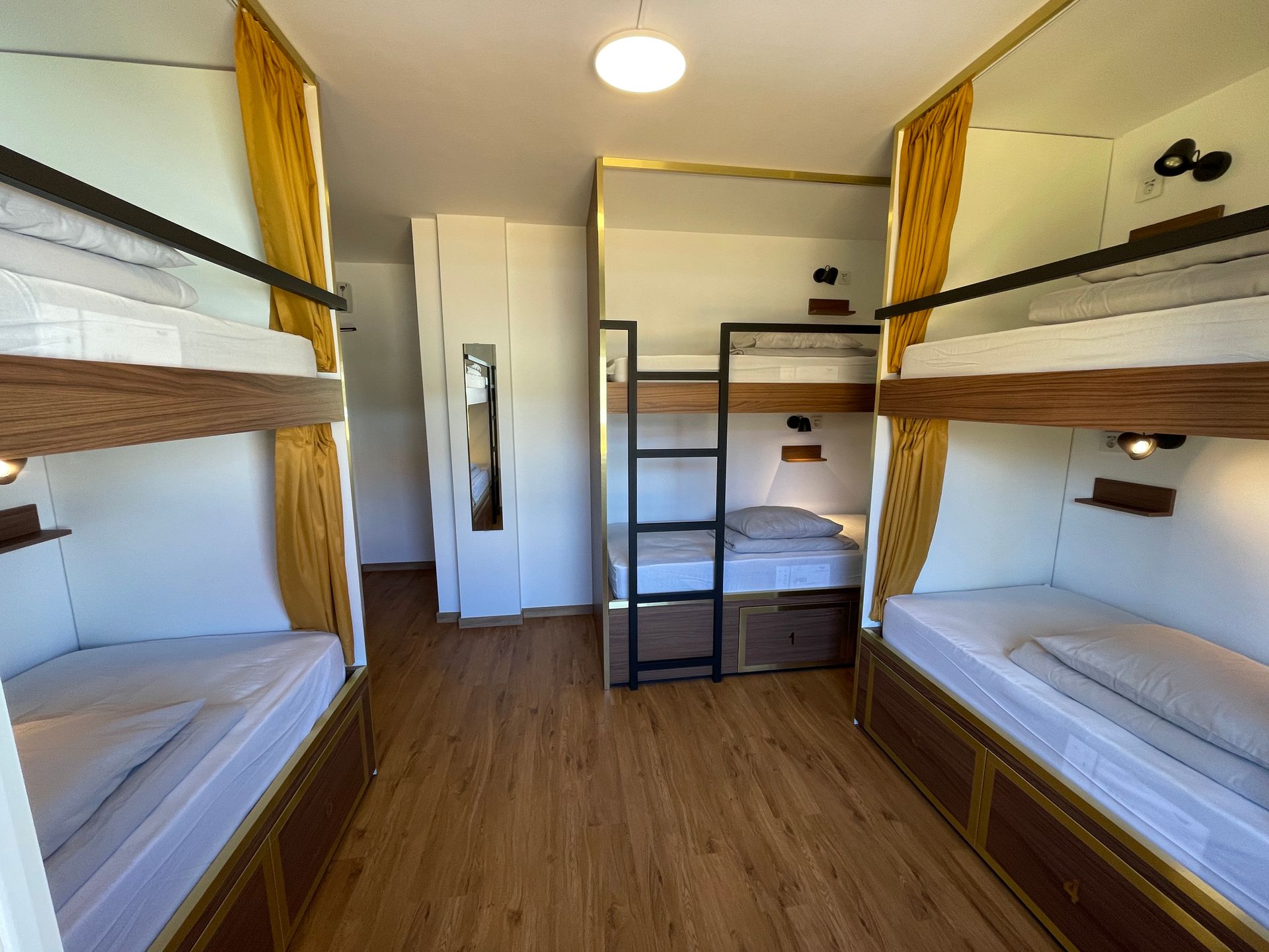 A room with four bunk beds and a ladder