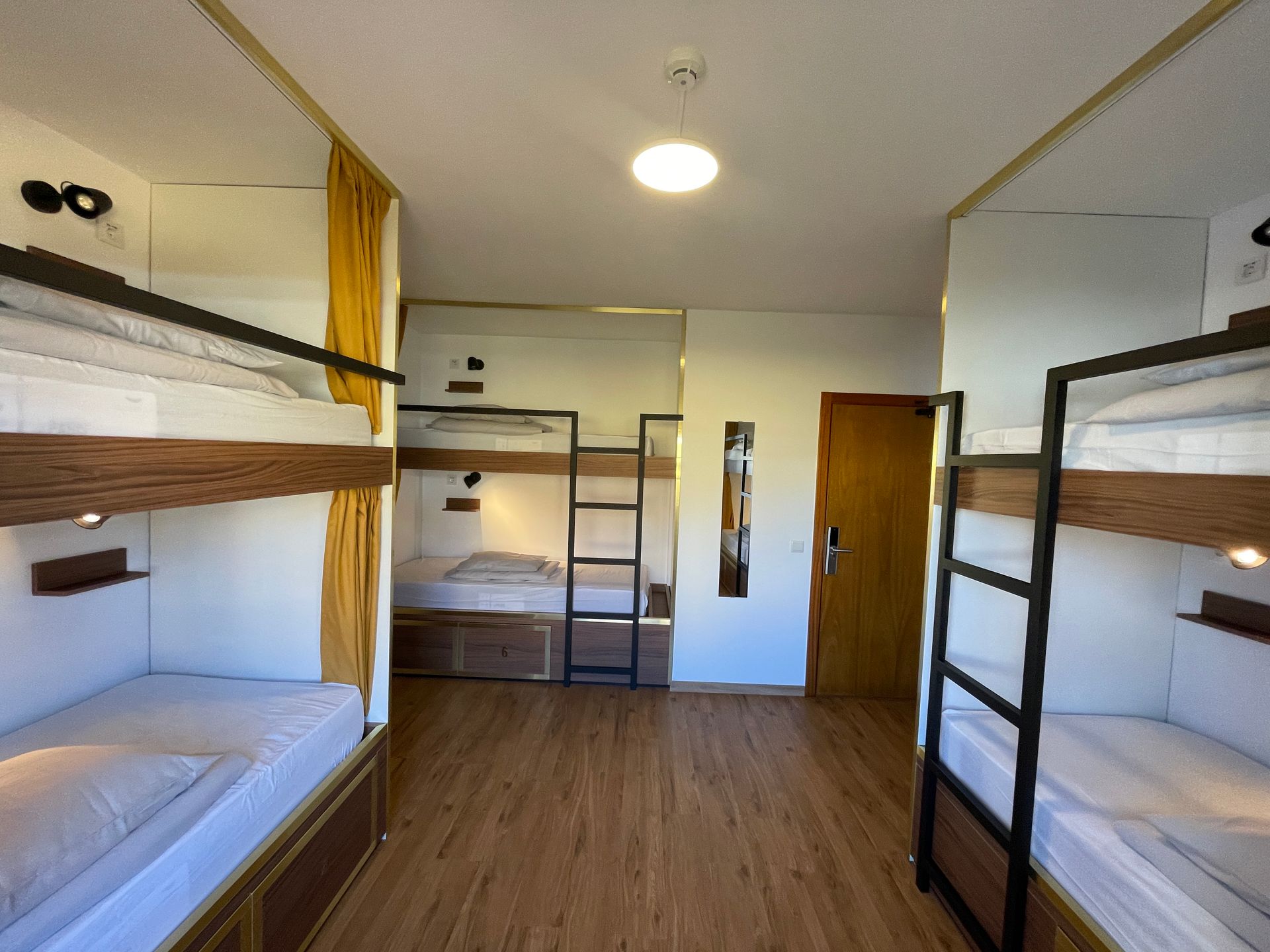 A room with four bunk beds and a door