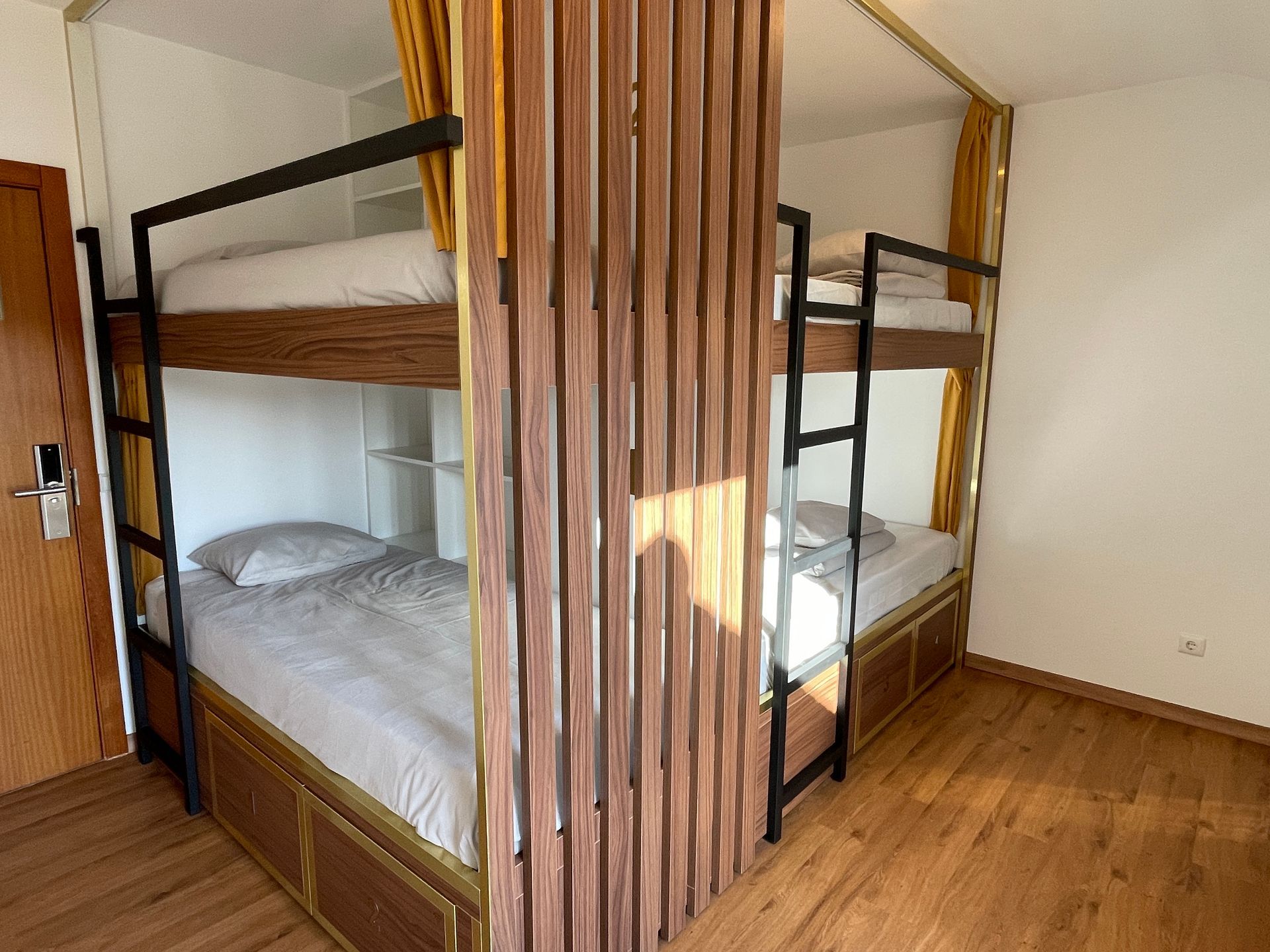 A room with two bunk beds and a wooden divider.
