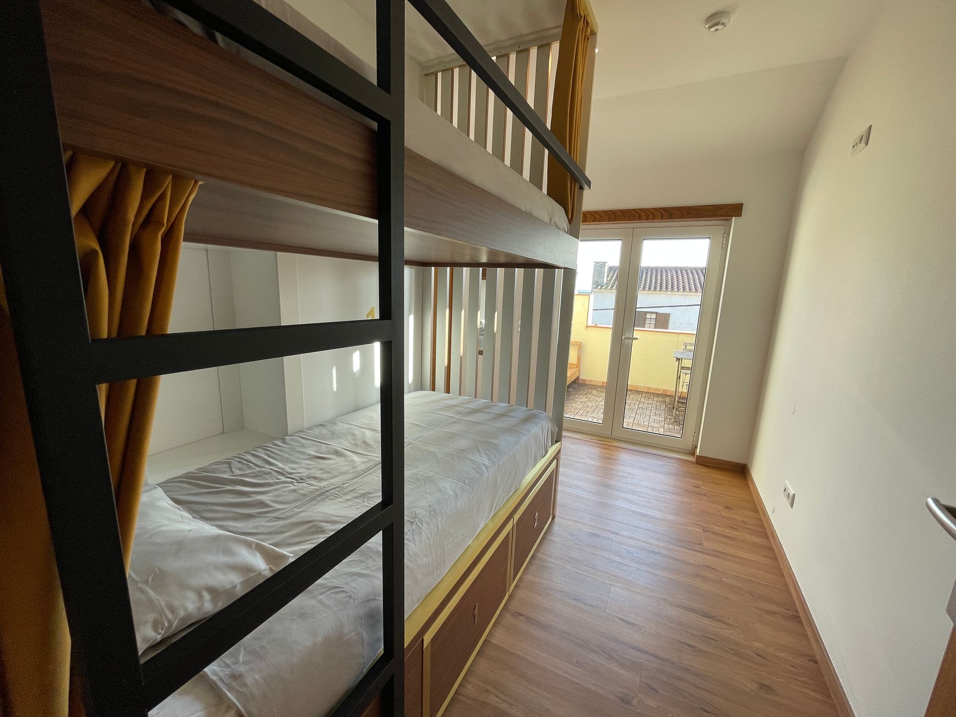 A bedroom with bunk beds and a sliding glass door.