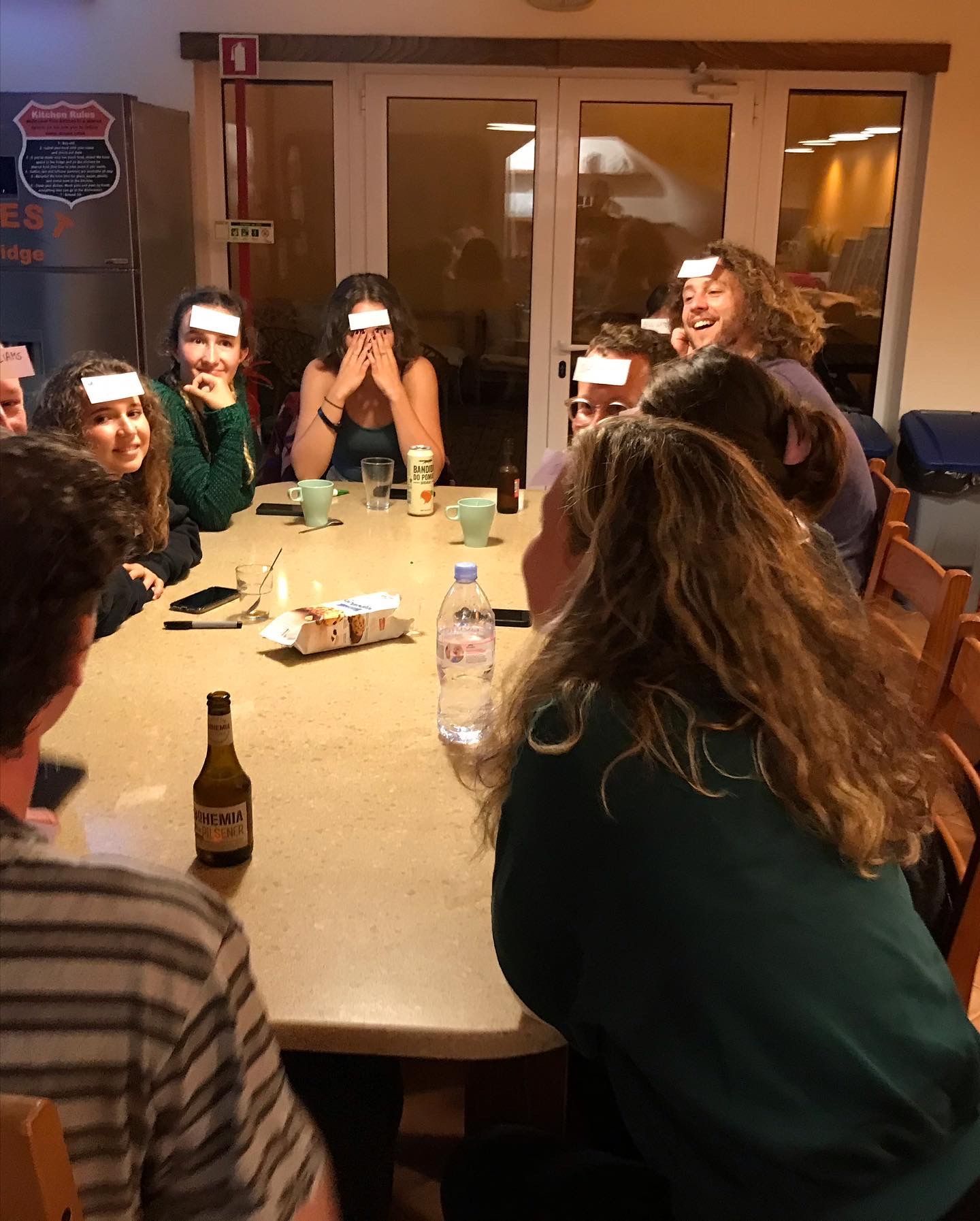 A group of people sitting around a table with their faces drawn on